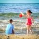 Ein Mädchen und ein Junge spielen am Meer