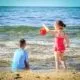 Ein Mädchen und ein Junge spielen am Meer